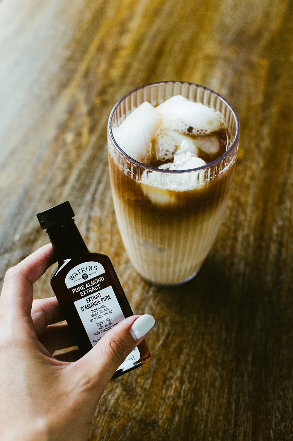 Watkins Almond Extract packaging on a counter emphasizes gluten-free and corn syrup-free claims.