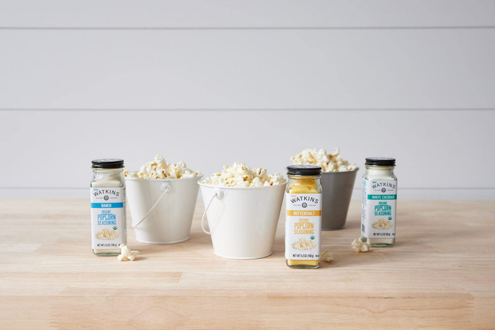 Watkins seasoning jar sits on a tidy kitchen counter beside popcorn.