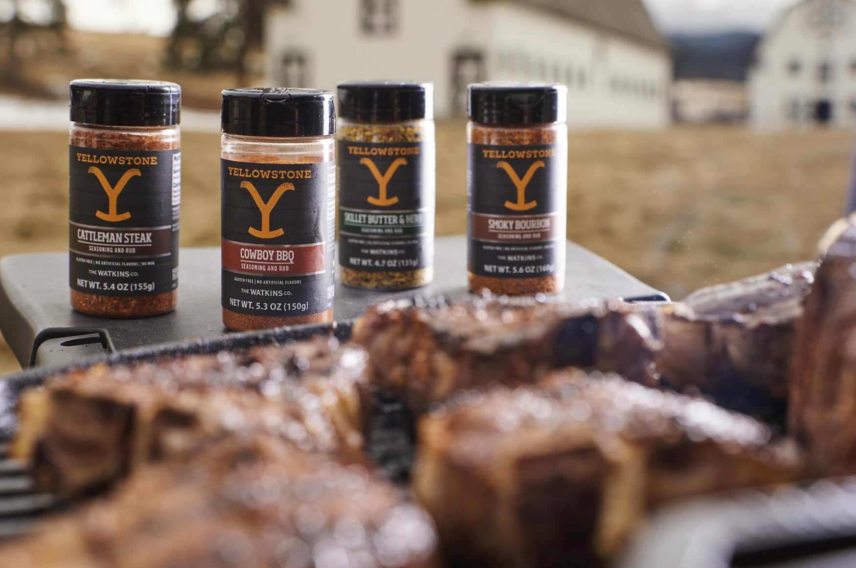 Watkins Yellowstone seasoning being sprinkled on chicken in a hot skillet
