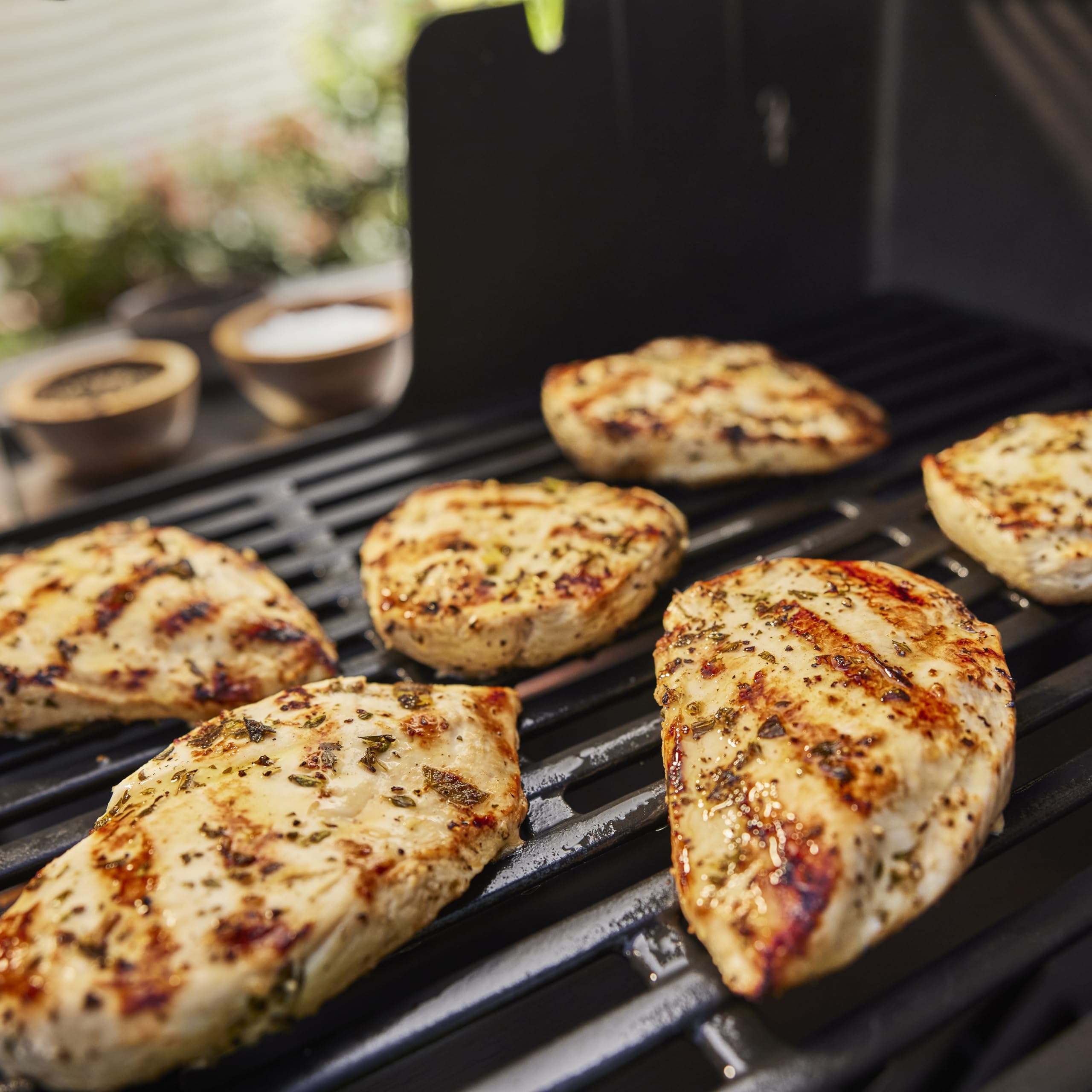 Spray delivering flavor to meat and vegetables on the grill
