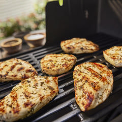 Spray delivering flavor to meat and vegetables on the grill