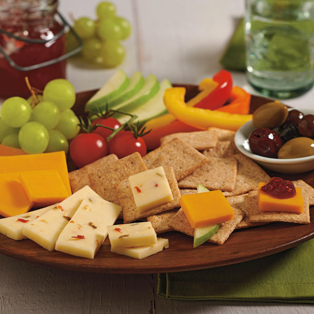 Wheat Thins Original crackers beside fruit and herbs on a platter.
