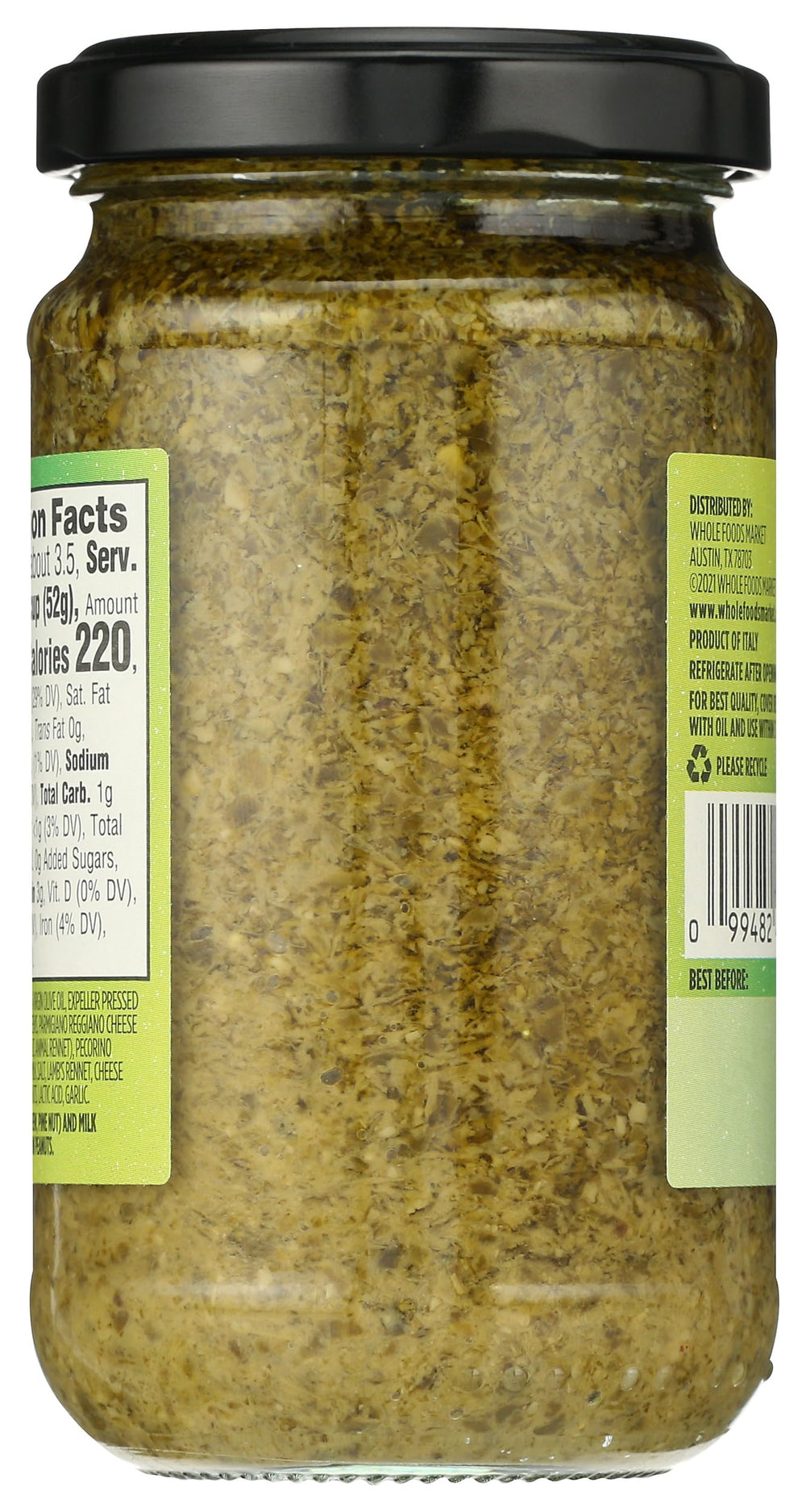 Whole Foods Market Basil Pesto bottle tilted, ready to pour.