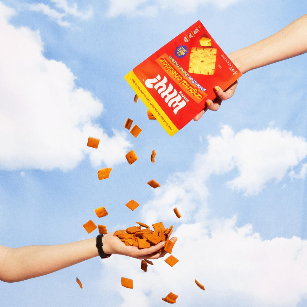 WHY? SNACKS bag opened to reveal crisp crackers and visible texture.
