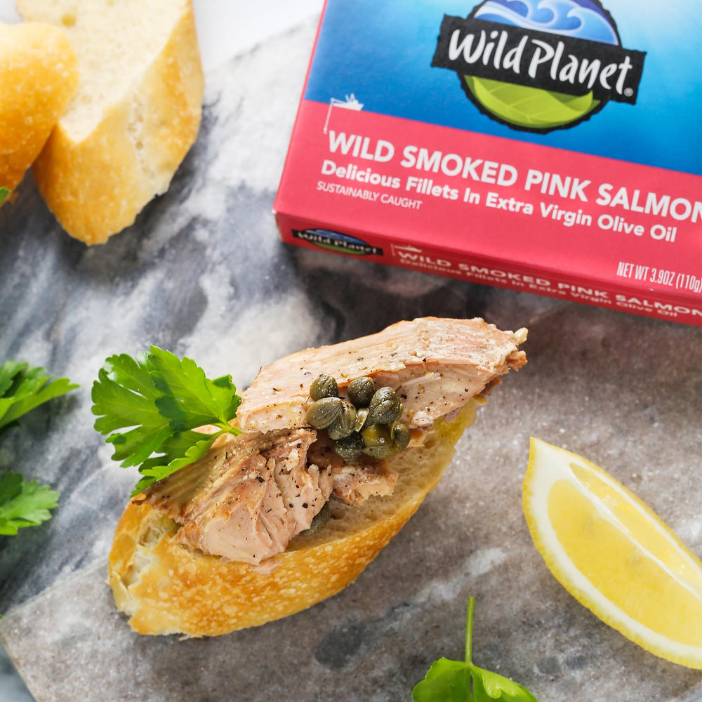 Wild Planet salmon on crackers with lemon, a quick, flavorful snack idea.