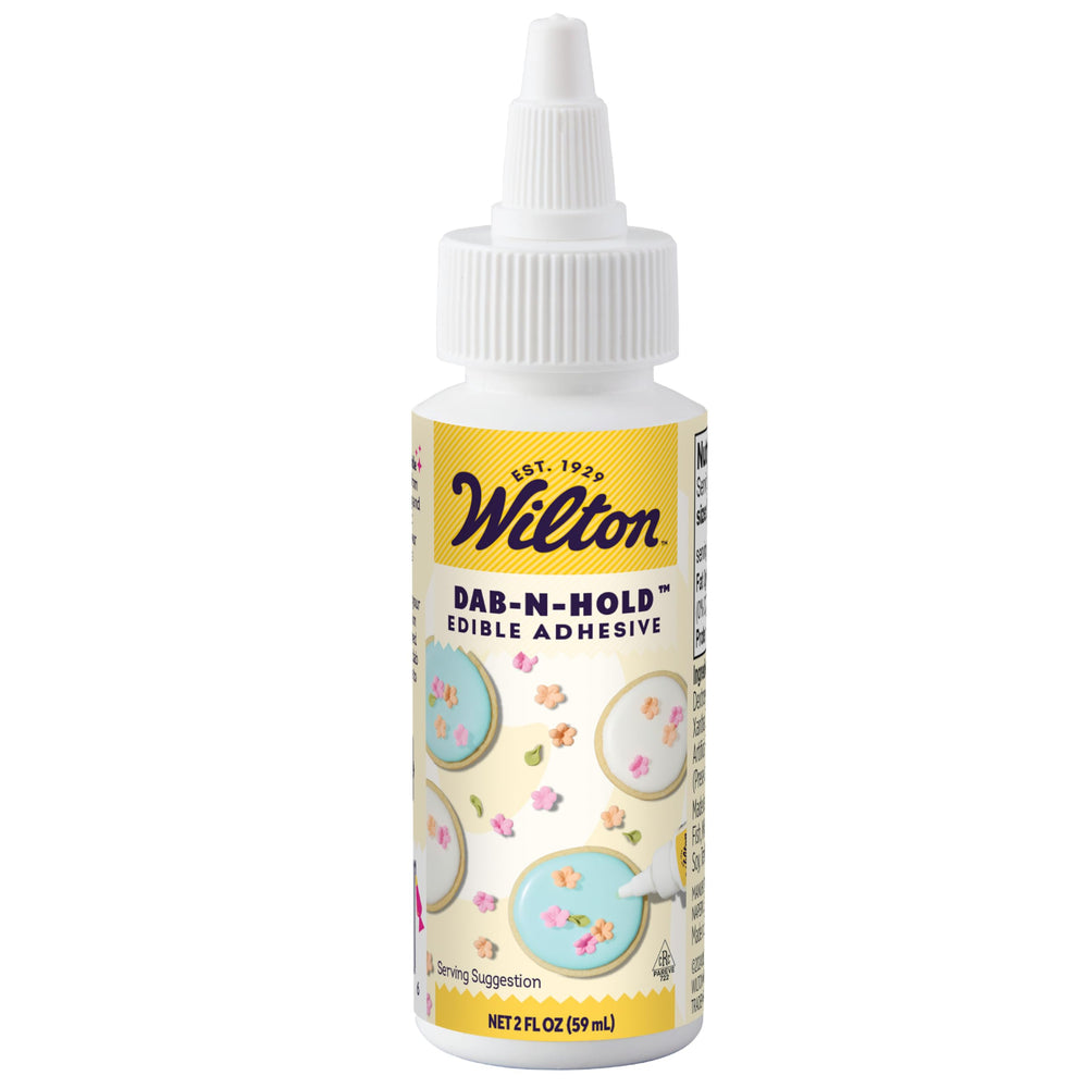 Wilton Dab-N-Hold bottle close-up showing clear edible adhesive for secure fondant.
