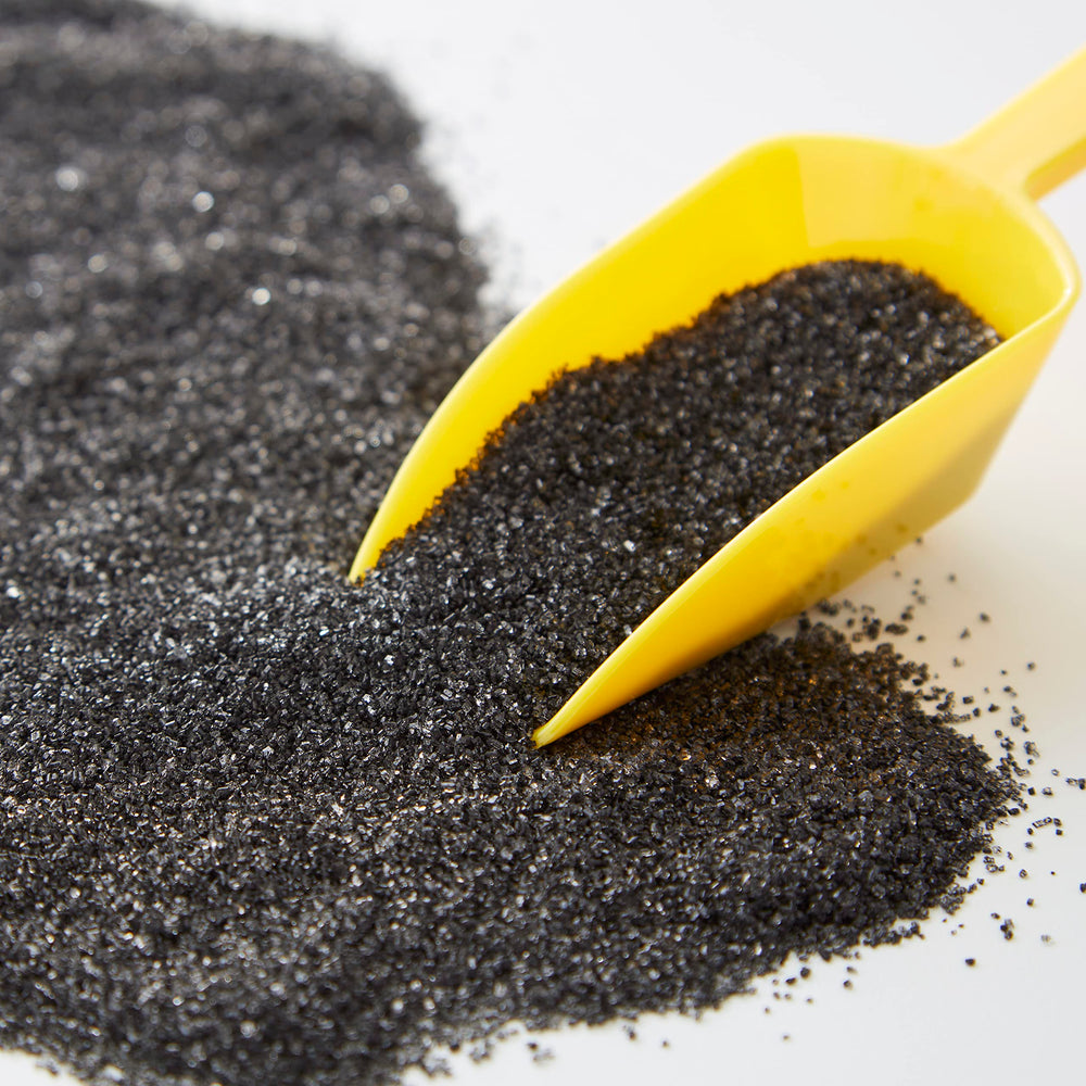 Wilton Sparkling Sugar Black being poured for precise sprinkles