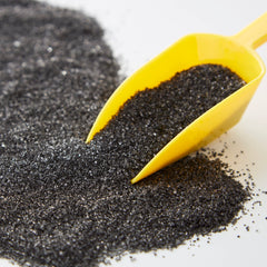 Wilton Sparkling Sugar Black being poured for precise sprinkles