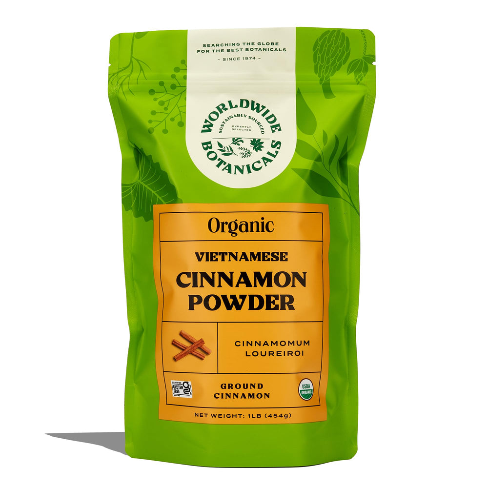 Worldwide Botanicals cinnamon powder being dusted on an apple pie for flavor