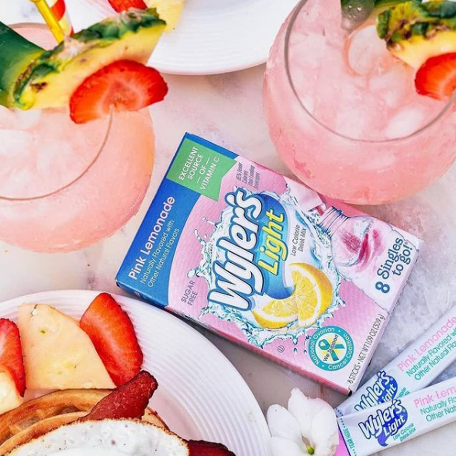 Pour-ready mix swirling into a glass, creating a pink lemonade hue.