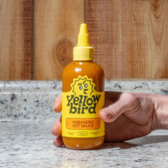 Two Yellowbird Classic Habanero bottles on pantry shelf for everyday flavor and heat.