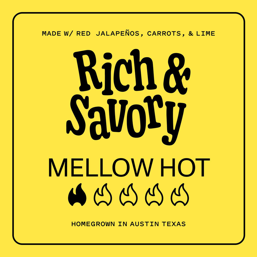 Glass bottle of Yellowbird sauce with pour ready for cooking.
