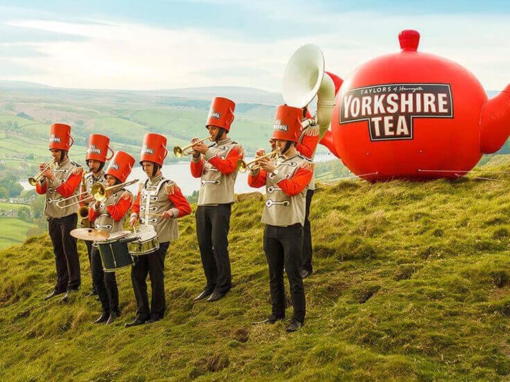 Yorkshire Tea red pillow tea bags being poured hot water.