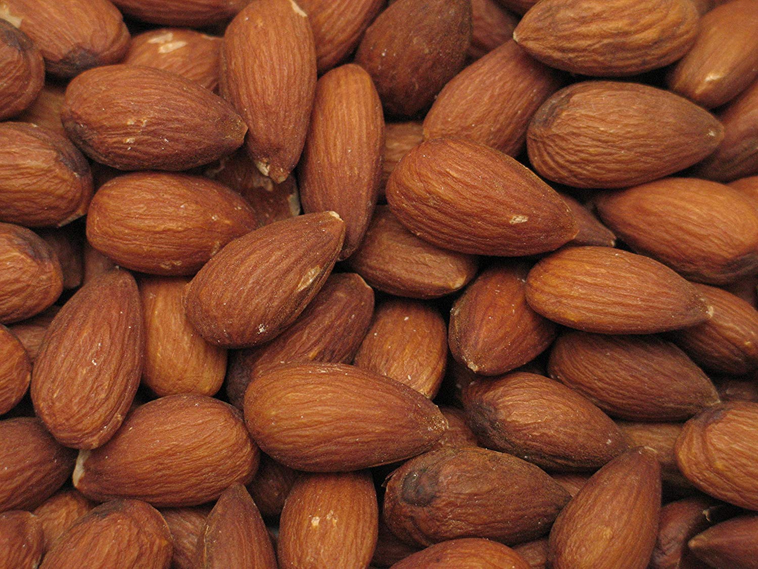 Yupik almonds spilled on a countertop highlighting gluten-free, vegan snack versatility.