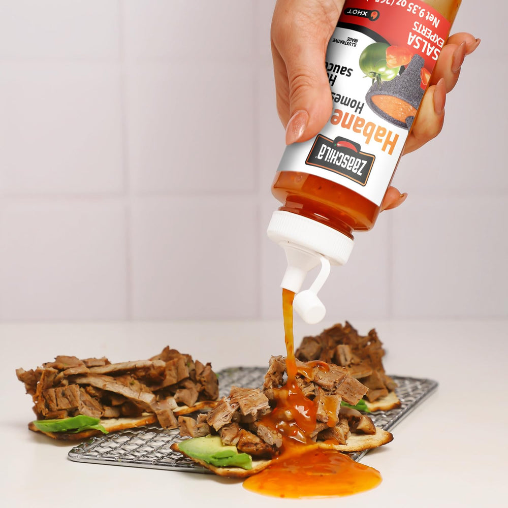 Spoon of Zaaschila sauce on tacos showcases bold heat.