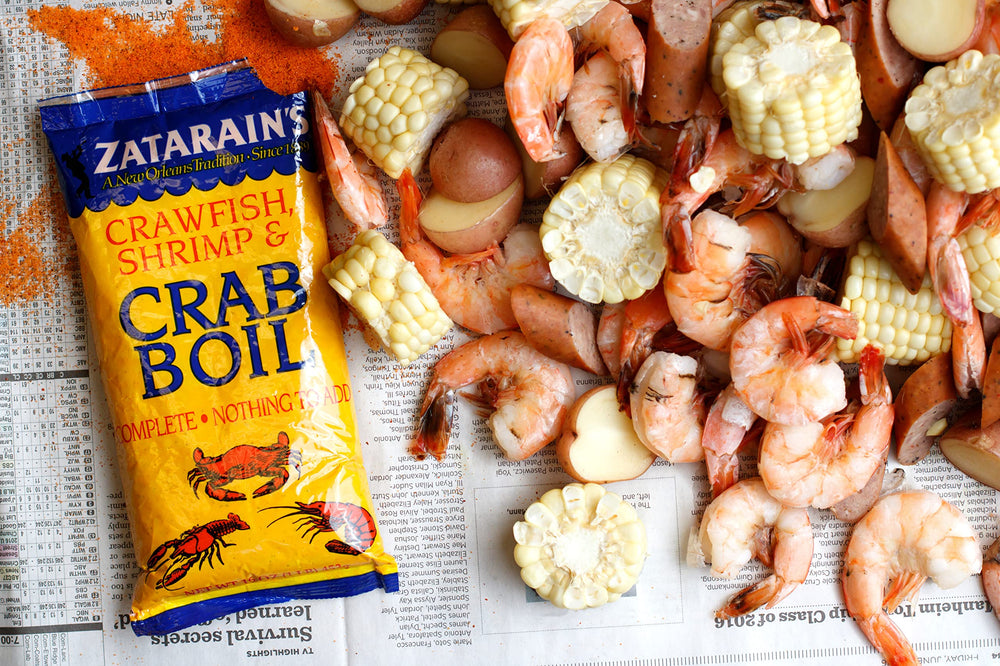 Family gathers around the table for a traditional seafood boil seasoned by Zatarain's.