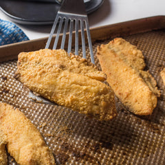 Zatarain's Fish Fri coating on catfish for crispy results.